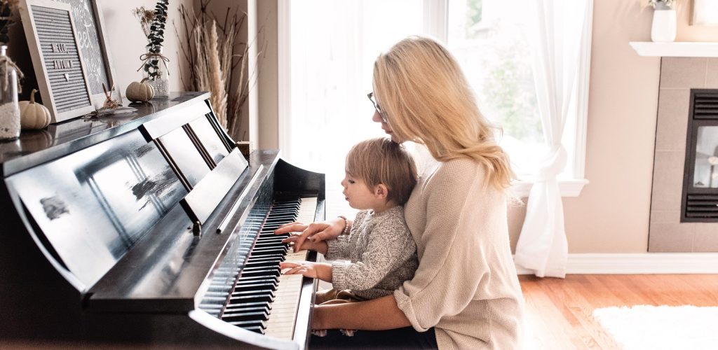A woman and a child playing a piano