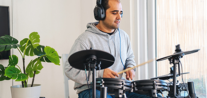 A man practicing digital drums at home