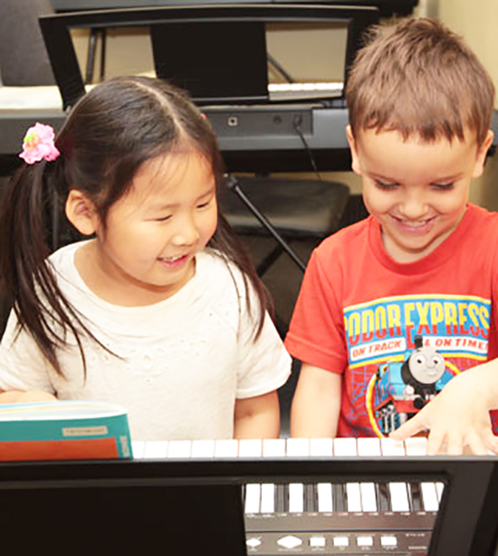 Two young music students learning piano together