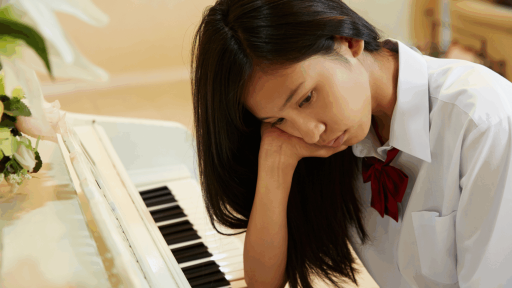 tudent looking frustrated while practicing piano at home