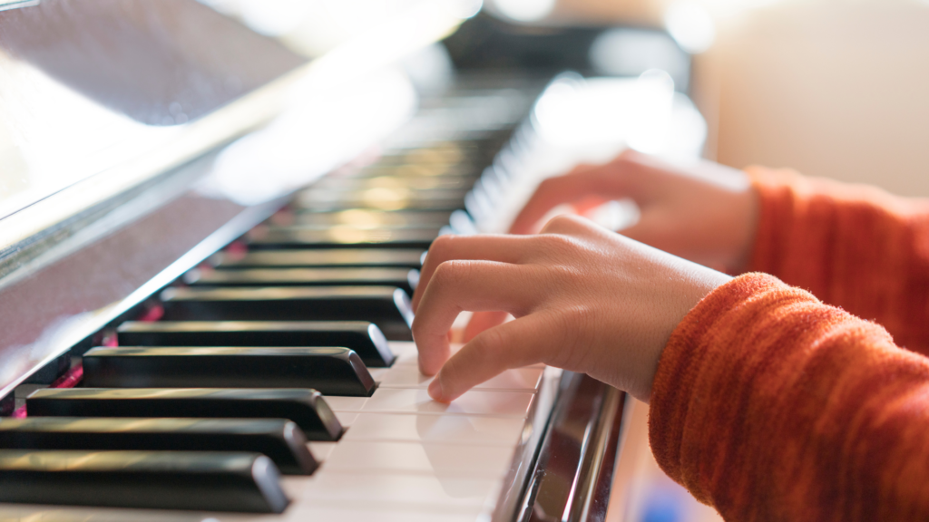 Child’s hands resting on piano keys during a beginner piano lesson