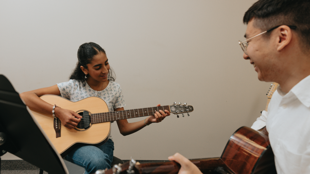 Guitar student and teacher during a lesson, showing what to expect in piano lessons for kids