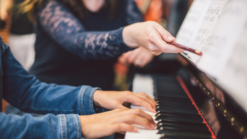 A young student takes music lessons Newmarket Aurora fall at The Piano Studio, seated at a piano with their teacher.