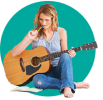 Woman sitting holding a guitar writing notes